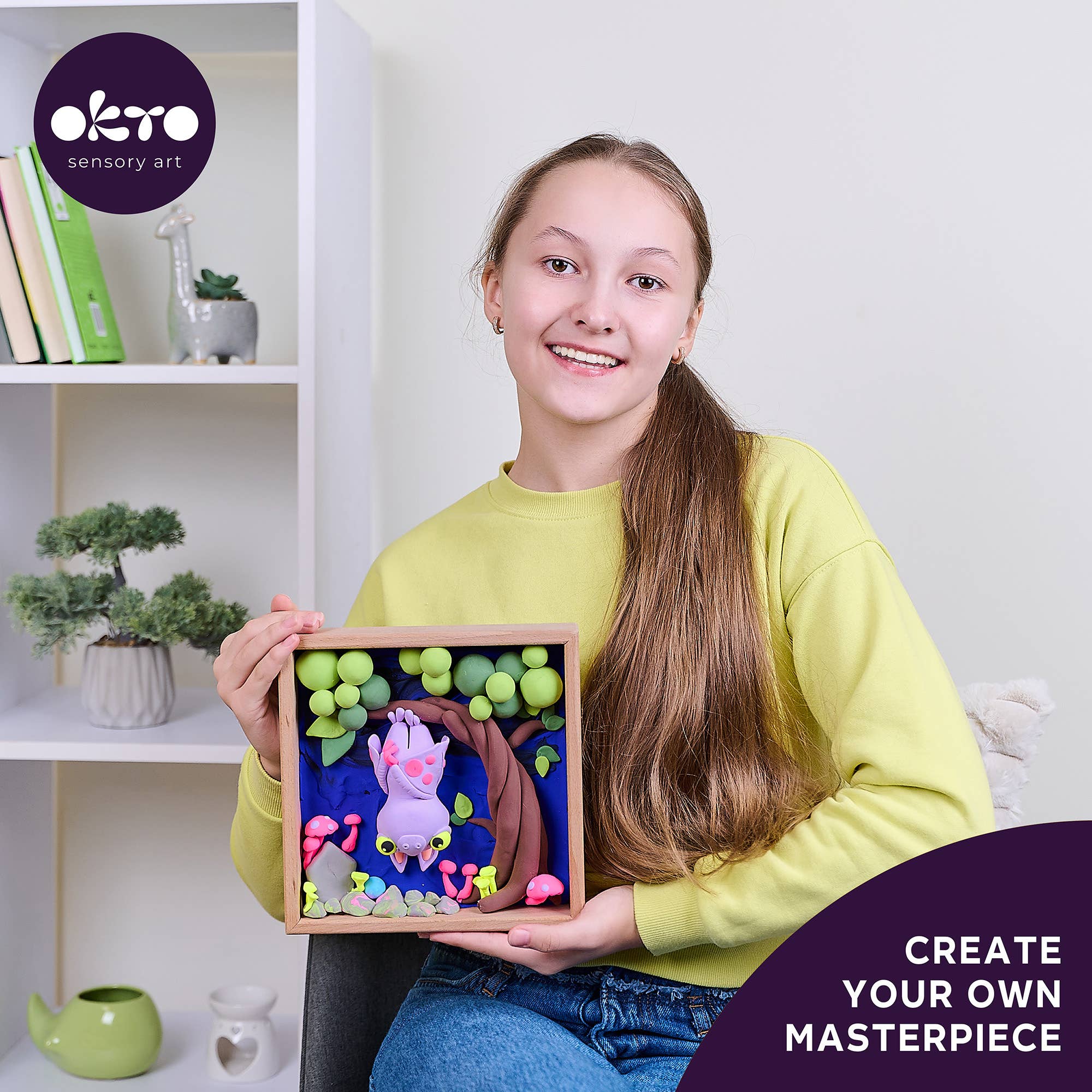 Person holding a framed artwork with 'oko' brand logo and text 'Create Your Own Masterpiece'.
