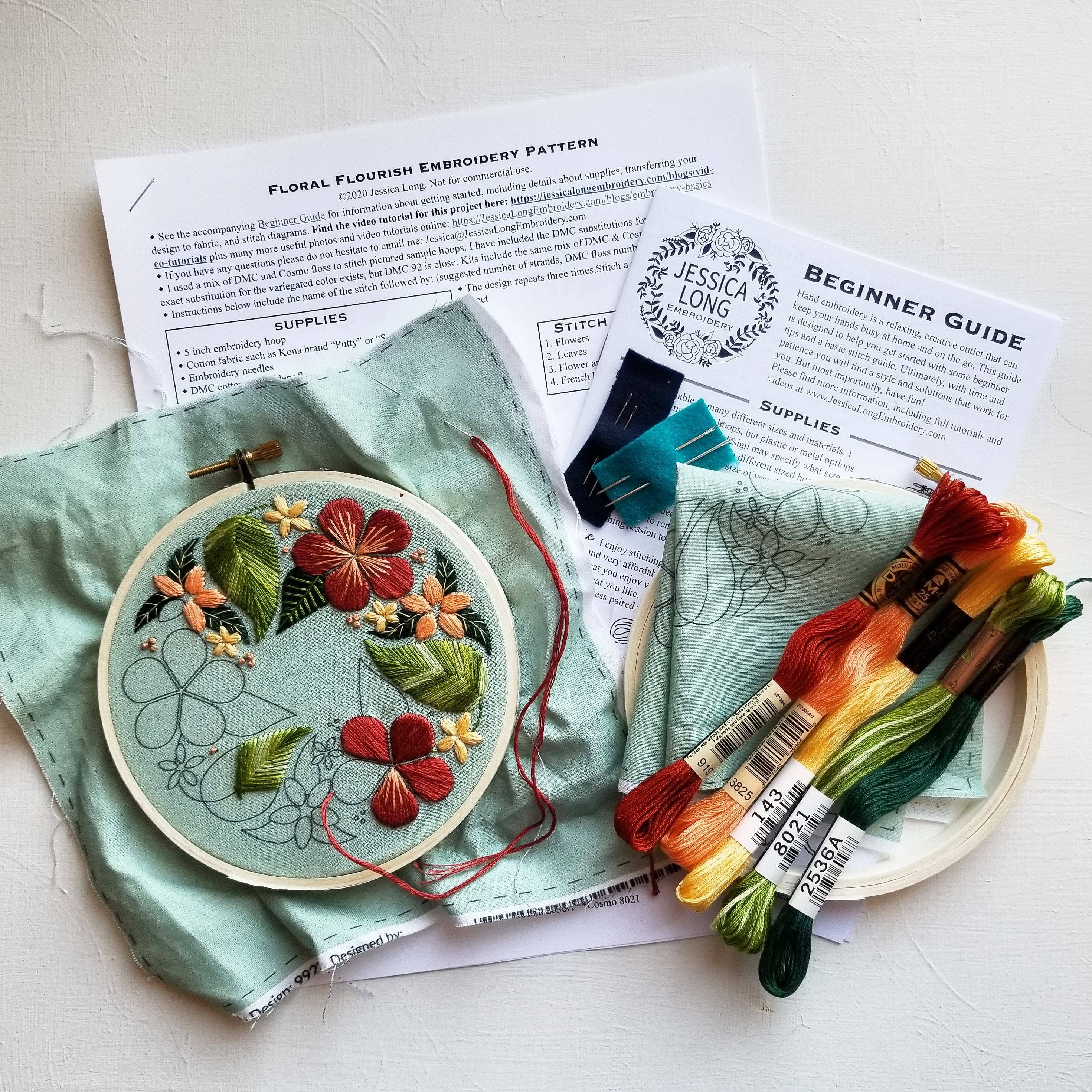 Embroidery kit with floral design, threads, and instructions on a light surface