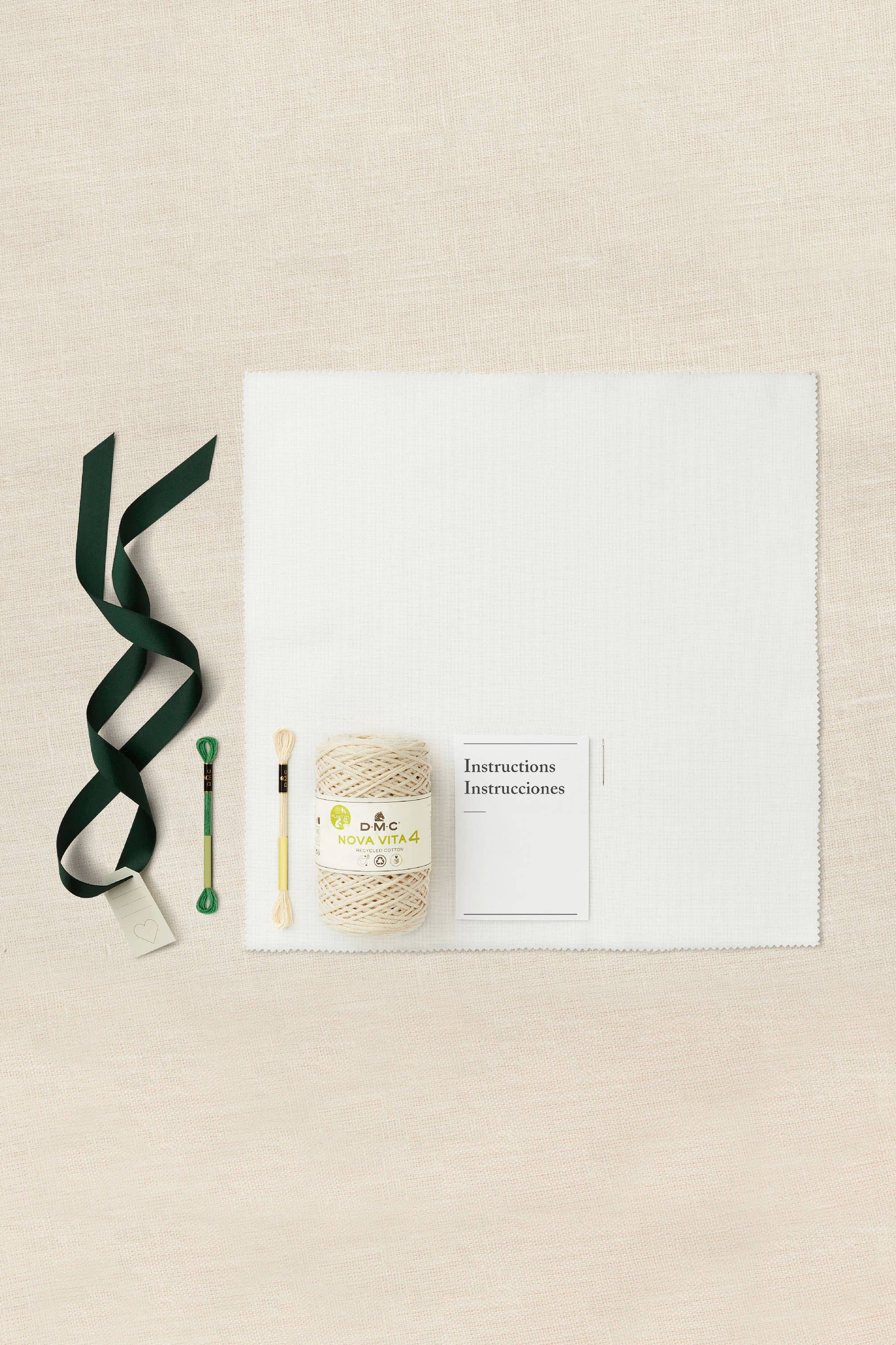 Yarn, knitting needles, and a card on a beige background