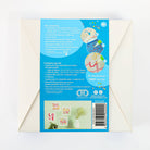 Craft kit packaging with blue label and white envelope on a light gray background