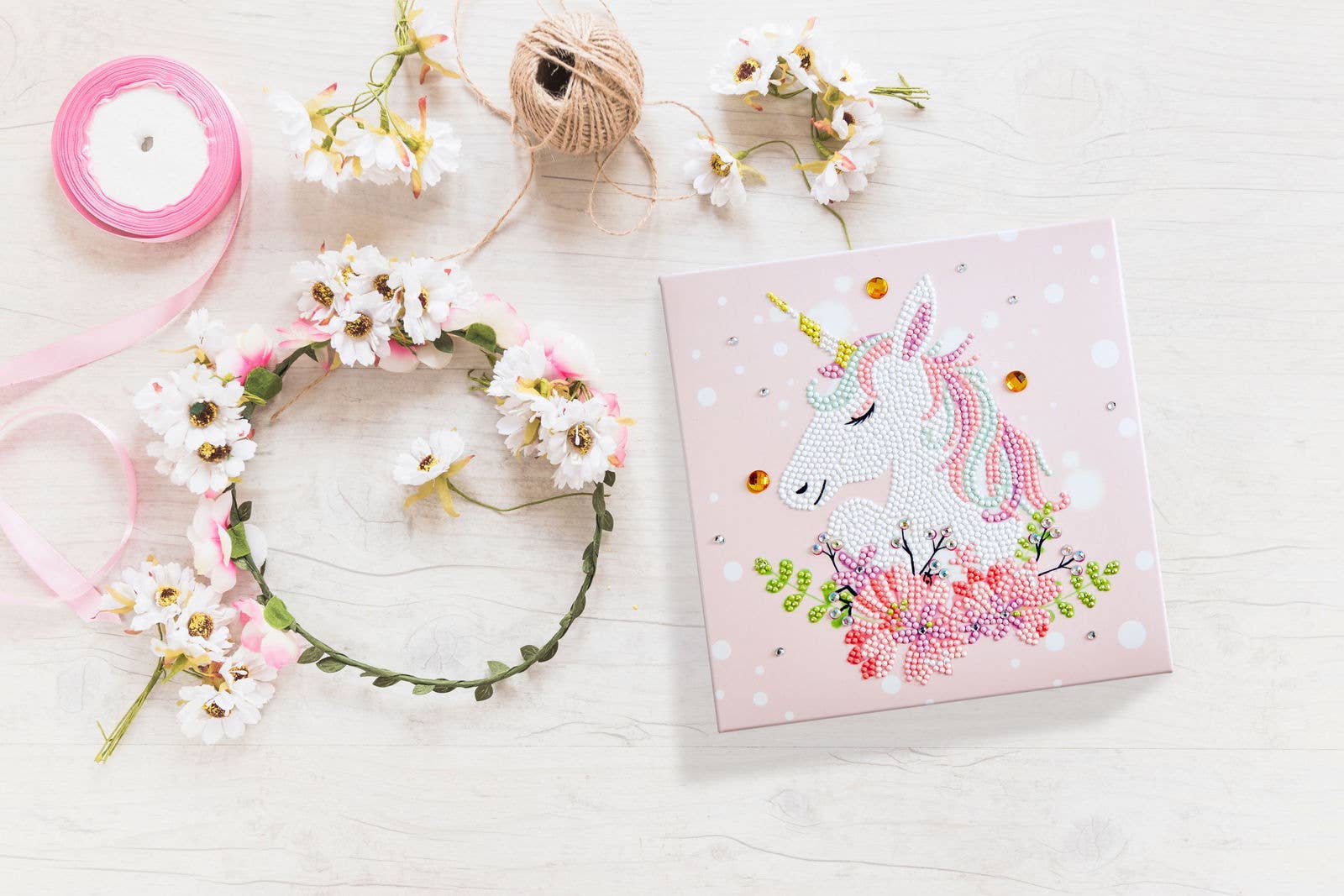 Card with unicorn design surrounded by flowers and ribbons on a white background