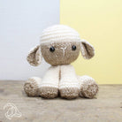 Knitted toy sheep on a wooden surface with a light background