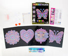 Diamond dotting kit with colorful designs on black paper and packaging on a white background