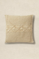 Beige woven pillow with decorative pattern on a beige background