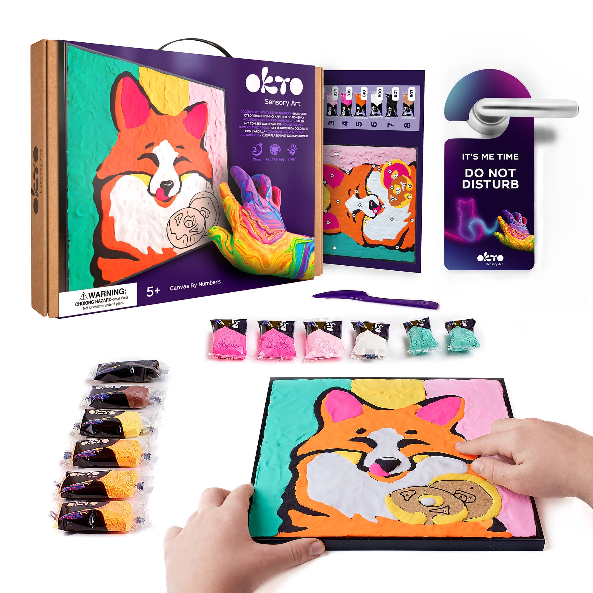Okro sensory art kit with coloring book, markers, and a child's hand holding the book.