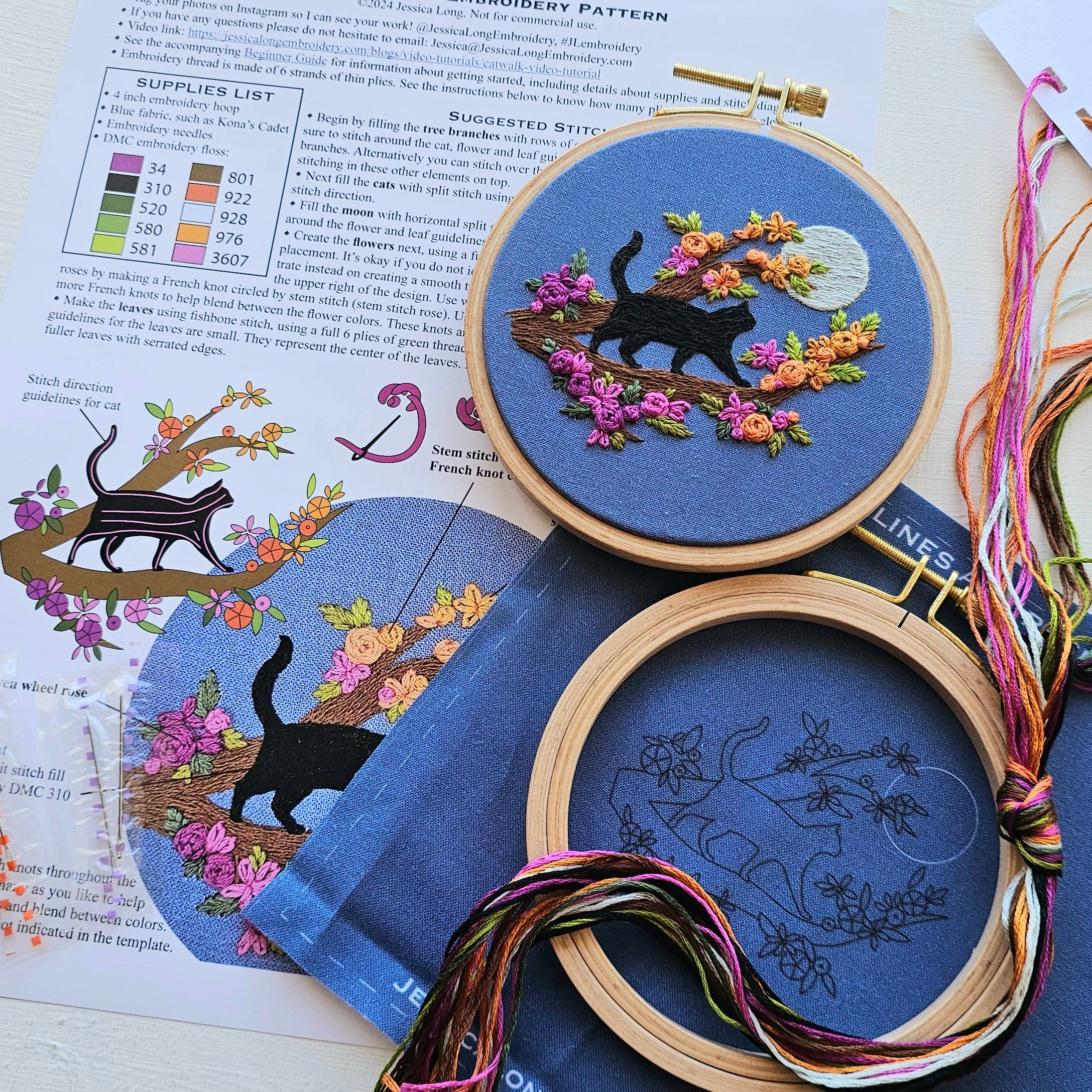 Embroidery hoops with cat and floral designs on a book page