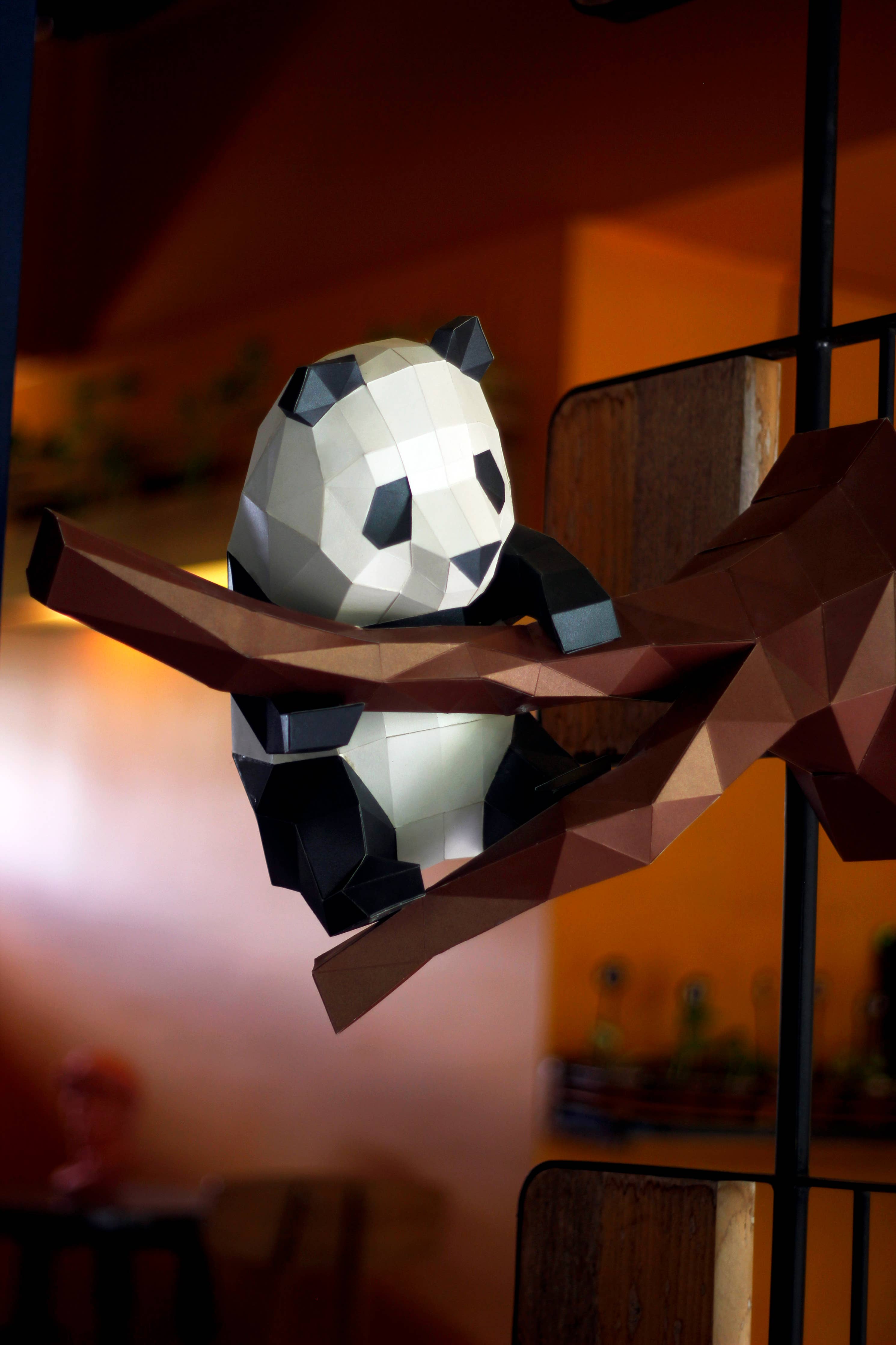 Panda-shaped lamp on a branch with a blurred background