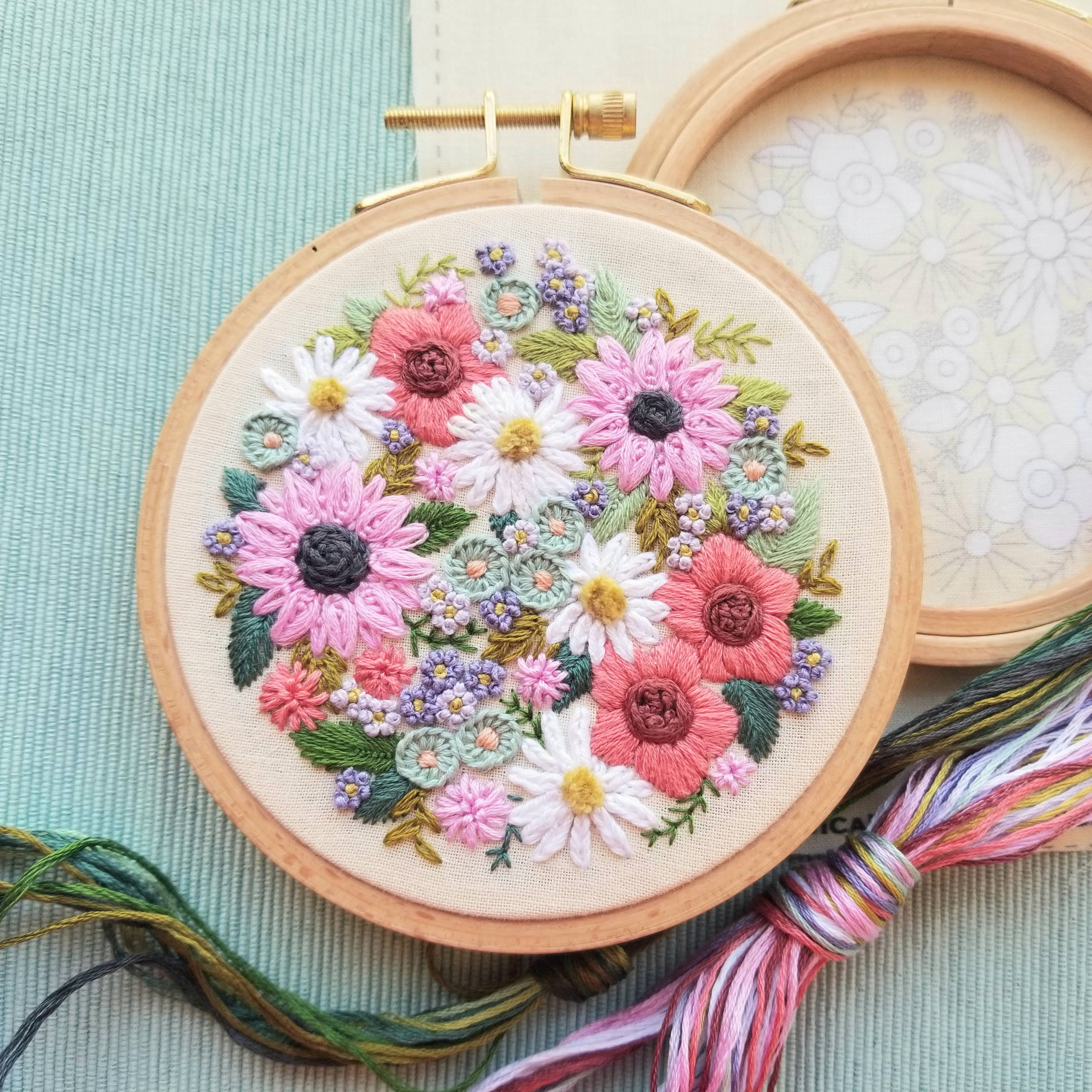 Embroidery hoop with floral design on a light blue background