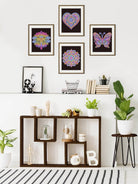 Decorative wall with framed artworks and a shelf with plants and books.