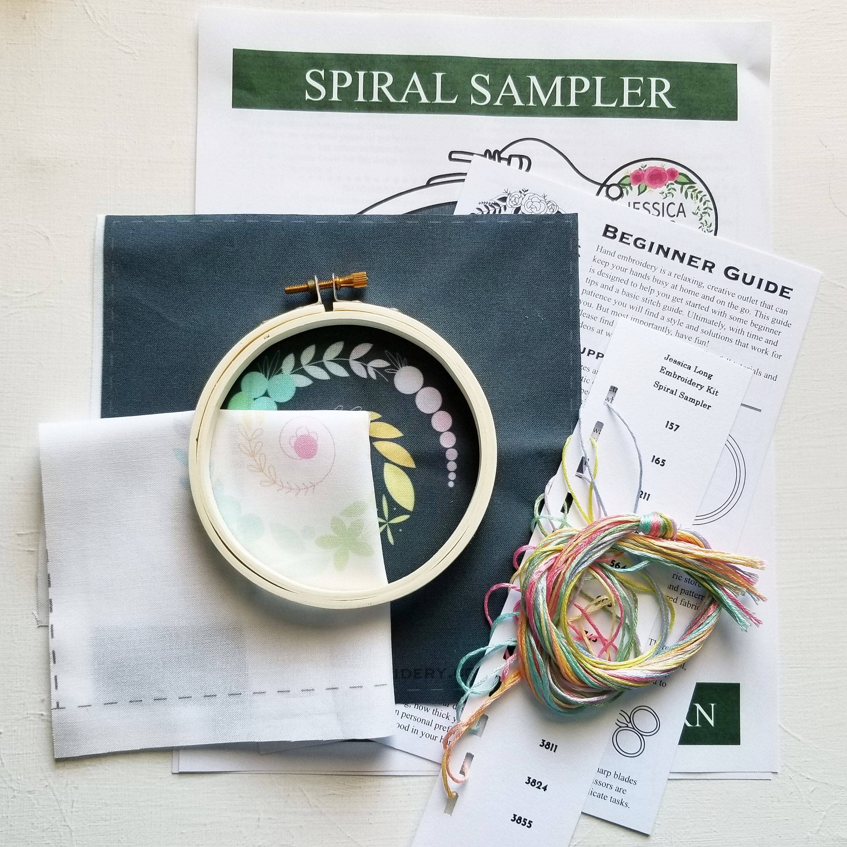 Embroidery kit with hoop, threads, and instructions on a white background