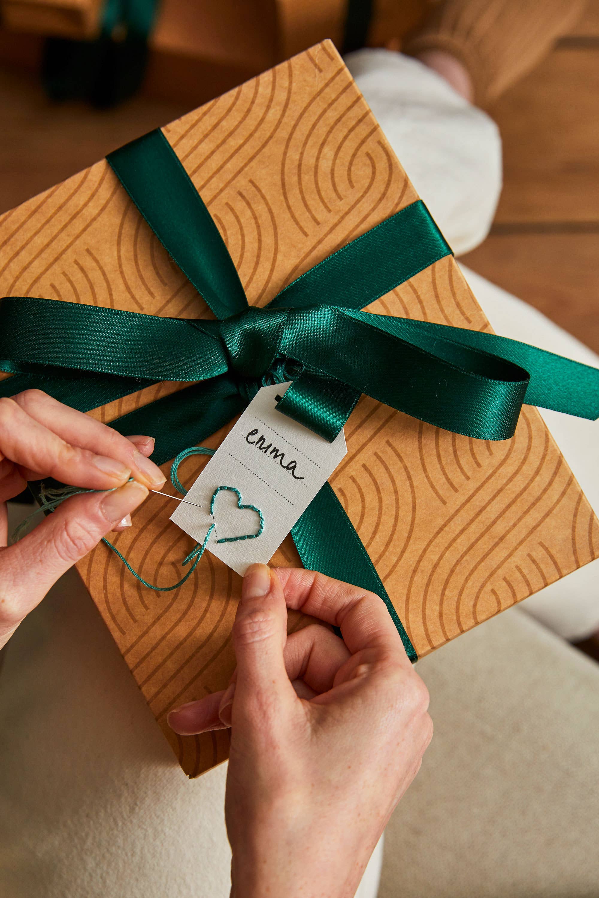 Person tying a green ribbon on a gift box with a 'crime' tag.