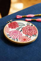 Embroidery hoop with floral design on a blue fabric background