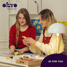 Two women engaging in sensory art activity with Okto Sensory Art branding.