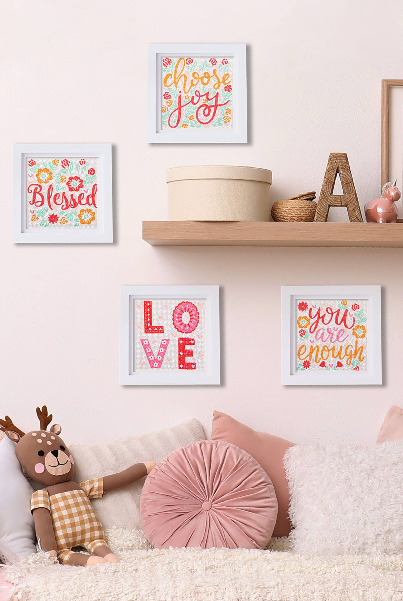 Decorative wall with framed quotes, a teddy bear, and pillows on a couch.