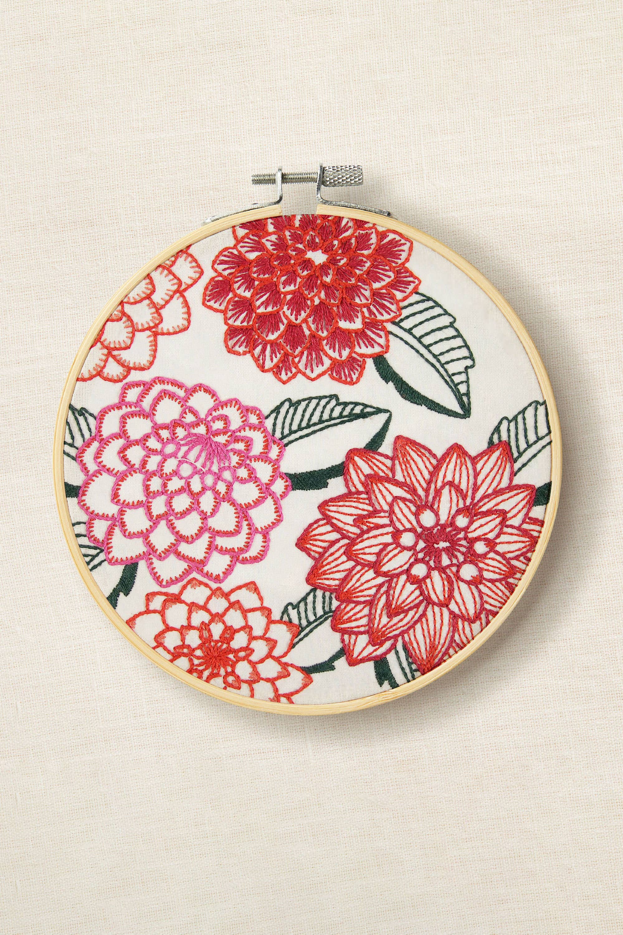 Embroidery hoop with floral design on a beige background