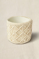 Decorative pot with macrame pattern on a beige background