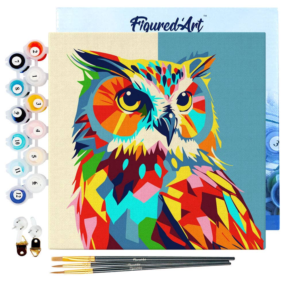 Colorful owl painting kit with paint bottles, brushes, and canvas featuring a completed colorful owl design.
