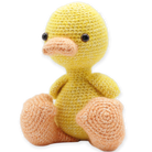 Crocheted yellow duck toy on a white background